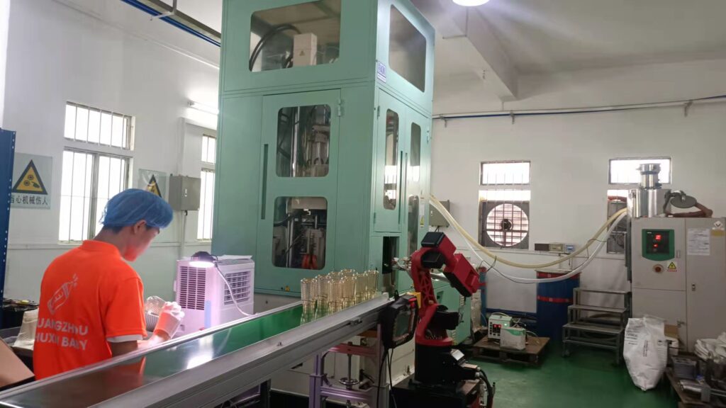 Baby bottle production line with automated conveyor and robotic arm at our manufacturing facility